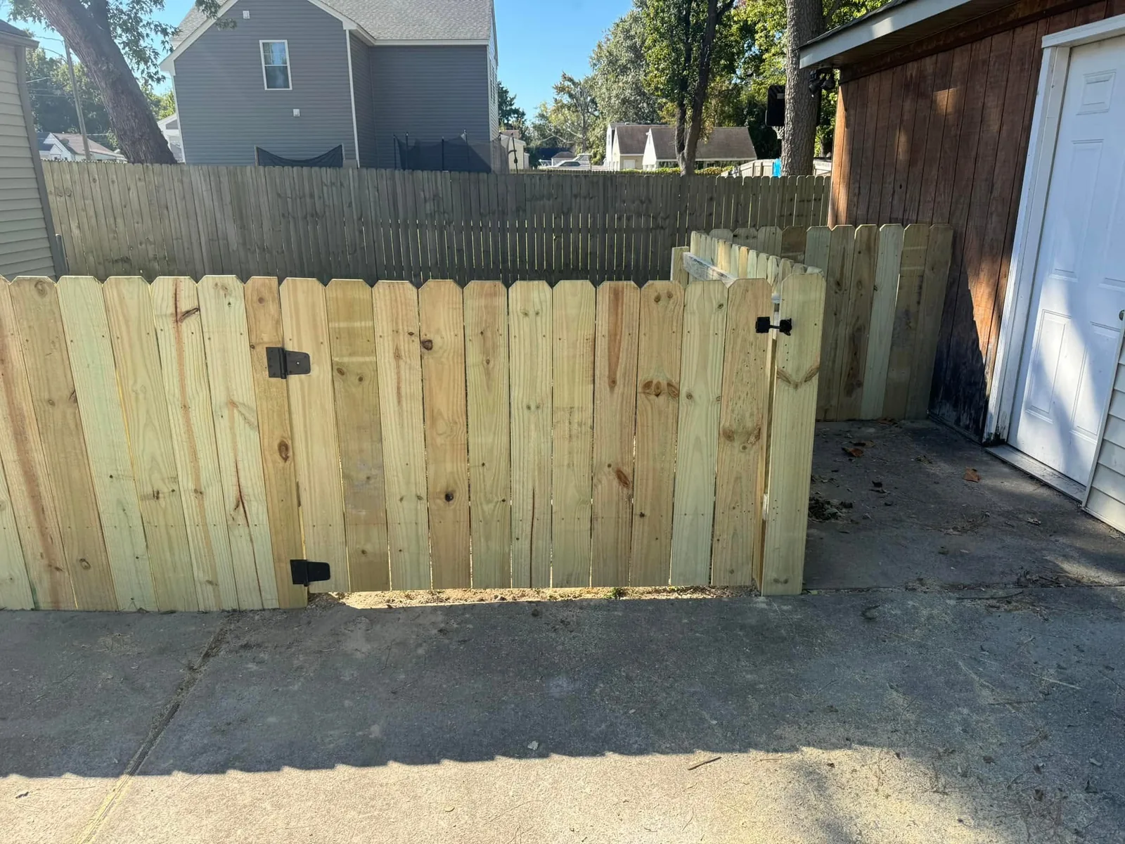 Wood fencing and a gate beside a garage
