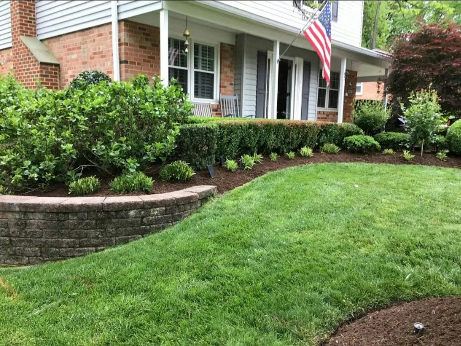 A green lawn and landscaped planting beds beside a home